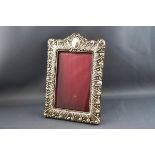 A Victorian silver embossed photograph frame, with red leather back and easel stand,