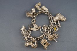 A sterling silver curb bracelet with fifteen assorted charms. Gross weight: 70.