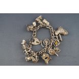 A sterling silver curb bracelet with fifteen assorted charms. Gross weight: 70.