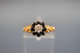 A hallmarked 9 carat gold cluster ring set with eight round sapphires measuring 2.