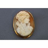 A yellow metal shell cameo brooch/pendant, depicting a classical female figure, Stamped 750.