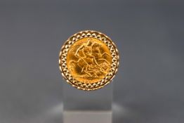 A yellow gold ring set with a half sovereign coin dated 1911.
