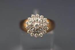 A yellow gold cluster ring set with twenty one round brilliant diamonds. 1.10ct.