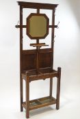 An early 20th century oak hall stand, central octagonal mirror with undershelf,