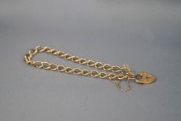 A yellow gold curb bracelet, padlock and safety chain. Hallmarked 9ct gold, London, 1991. 8.