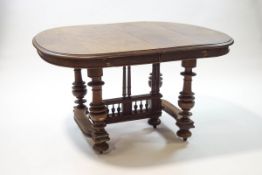 A 19th century oak extending dining table with three additional leaves on turned legs with central
