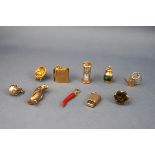 An assortment of ten yellow gold charms to include a Seal fob, Holy bible (with paper), Globe,