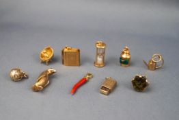 An assortment of ten yellow gold charms to include a Seal fob, Holy bible (with paper), Globe,