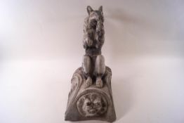 A lead garden figure of a squirrel eating a nut, seated upon a square base,