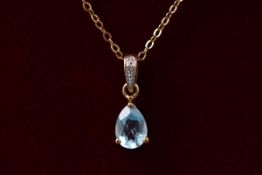 A yellow gold blue topaz and diamond pendant on a fine 9ct gold trace link chain. 1.