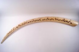 An early 20th century Indian ivory elephant tusk, carved with various animals,