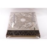 A silver plated wedding cake stand, profusely engraved with related motifs, 45cm square,