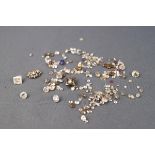 A collection of loose diamonds together with some stone settings and small corundum stones.