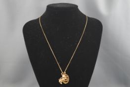 An 18 carat gold filed curb chain with two 9ct gold pendants. Gross weight: 10.