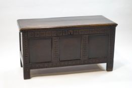 A 17th century oak triple panel coffer with carved square and diamond motifs,