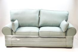 A modern pale green three seater sofa,