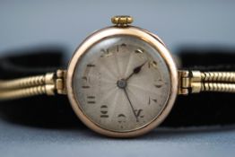A yellow gold ladies wristwatch by Rolex. Silver dial with numerical markings.