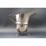 A silver milk jug, with double scroll handle standing on three cast lion mask and paw feet,