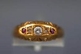 A yellow gold half hoop ring set with three diamonds and two rubies.