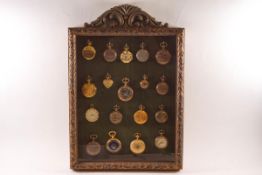 A collection of eighteen plated pocket watches within a glazed case,
