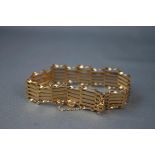 A yellow gold six bar gate bracelet, twisted and plain. Padlock and safety chain.