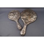 Two silver mounted hand mirrors, each embossed with five angle heads amongst clouds,