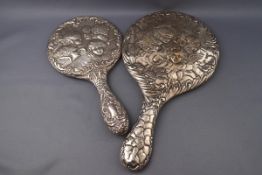 Two silver mounted hand mirrors, each embossed with five angle heads amongst clouds,