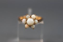 A yellow gold dress ring set with seven round cabochon opals (low commercial quality) Yellow shank,