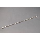 A white gold bracelet having sixteen diamond clusters, 2ct weight in total,