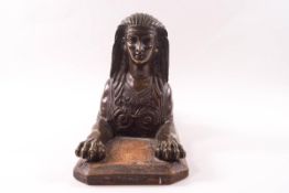 An early 19th century bronze model of an Egyptian sphinx, on a replacement wooden base,