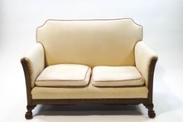 An early 20th century mahogany two seat sofa and matching armchair,