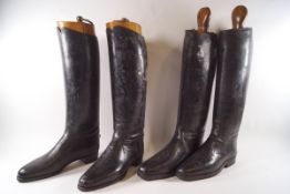 Two pairs of Gentleman's black leather riding boots with wooden trees,