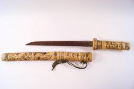 A 20th century Japanese bone handled knife within a carved bone sheath,