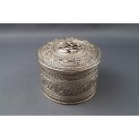 A 19th century Indian white metal cylindrical box and cover,