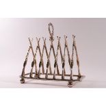 A large silver plated toast rack modelled as crossed rifles with a wreath holder,