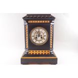 A Victorian black slate eight day mantel clock with visible escapement,