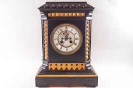 A Victorian black slate eight day mantel clock with visible escapement,