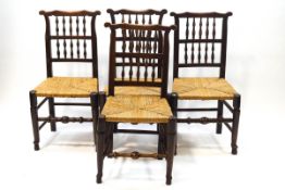 A set of four elm 18th century (?) spindle back dining chairs with rush seats,