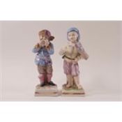 A pair of 19th century German porcelain figures modelled as boys decorated in polychrome enamels,