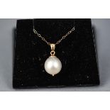 A yellow gold single stone pendant set with a white south sea cultured pearl, 10.