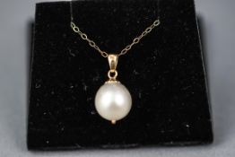 A yellow gold single stone pendant set with a white south sea cultured pearl, 10.