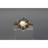 A yellow gold cluster ring set with a single pearl and six round aquamarines.