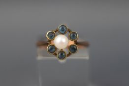 A yellow gold cluster ring set with a single pearl and six round aquamarines.