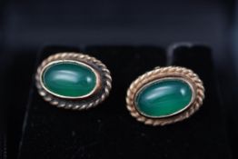 A yellow gold pair of 9ct gold stud earrings each set with green chalcedony cabochon.