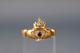 A yellow gold Claddagh ring set with a single garnet and a single cut diamond (I3+ clarity) Stamped