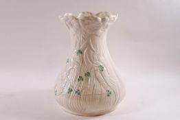 A Belleek porcelain vase modelled as a field of poppies with over painted shamrocks,