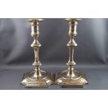 A pair of silver candlesticks with round capitals and nozzles, knopped stems on sunk centre,