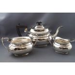 A three piece silver tea set, of boat shape, the teapot with ebonised knop and handle,