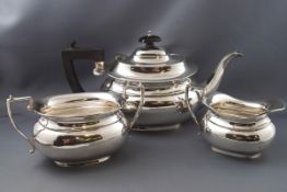 A three piece silver tea set, of boat shape, the teapot with ebonised knop and handle,