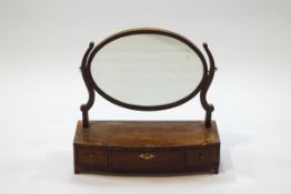 A 19th century oval swing frame mirror on bow front box base with three drawers,